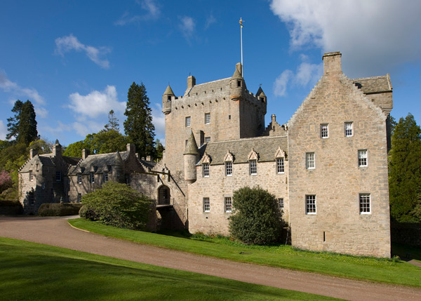 stone castle surrounded by trees with clear blue sky showcasing historical architecture and scenic landscape in the background 1 castle features 1 historical significance 1 picturesque views