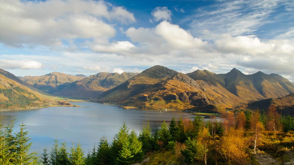 landscape view of mountains and lake under a blue sky trees and autumn foliage scenic beauty three peaks in distance