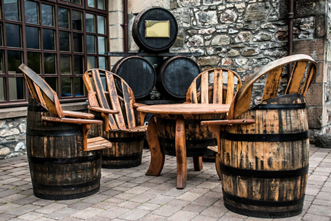 wooden furniture set made from barrels four chairs and a round table on stone patio